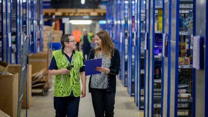 Two people walking in a warehouse