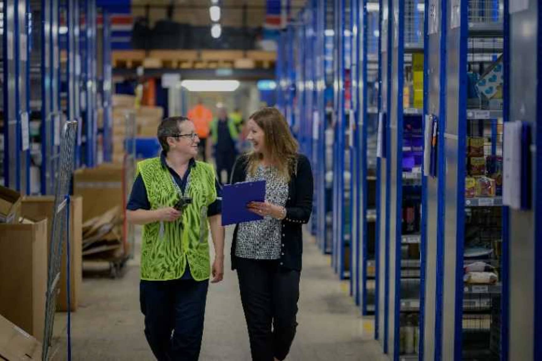 Two women walking through a warehouse